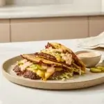 Smash burger tacos with crispy beef, melty cheese, lettuce and Big Mac sauce on a beige ceramic plate