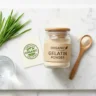 Organic gelatin powder in glass jar with wooden spoon and organic certification on white marble surface