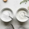 Two bowls of white powder side by side, labeled baking soda and baking powder