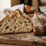 A rustic sourdough boule cut open showing an airy interior crumb