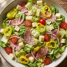 Italian grinder salad with salami, provolone, and banana peppers in a bowl