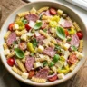 Italian grinder pasta salad with rotini, salami, and provolone in a bowl