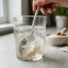 Psyllium husk powder being stirred into a glass of water