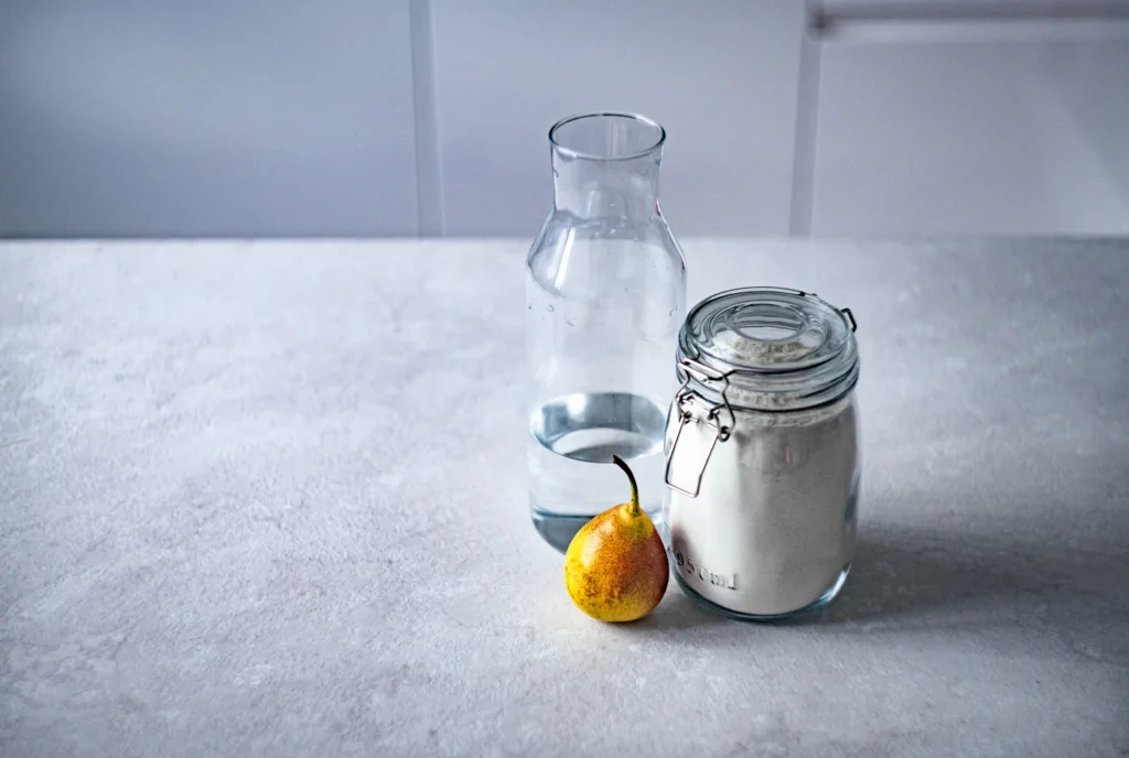 Glass of water beside a clear kitchen canister