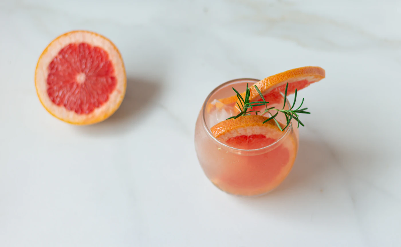 Grapefruit drink served over ice with rosemary