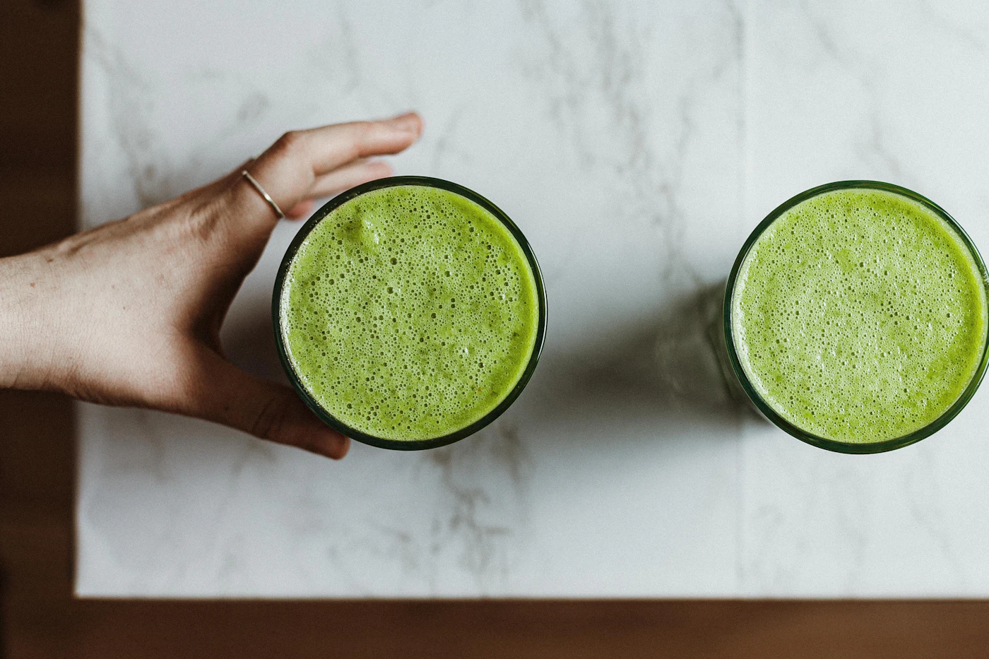 Green protein shake with spinach in a clear glass