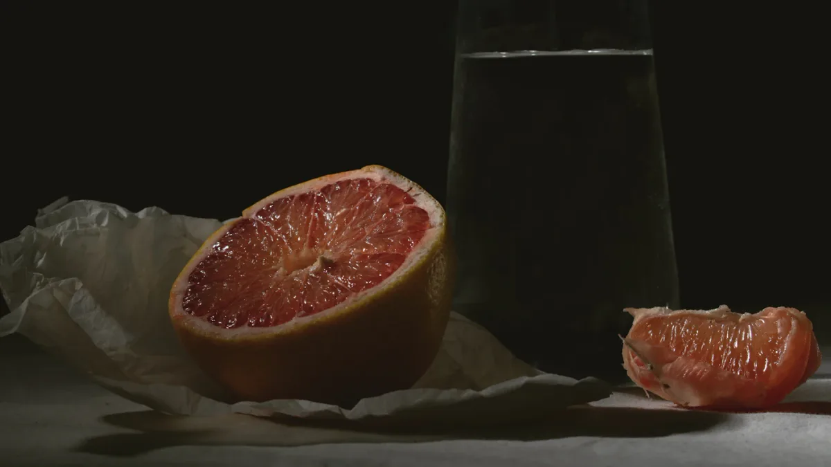 Grapefruit cut in half beside a glass of water