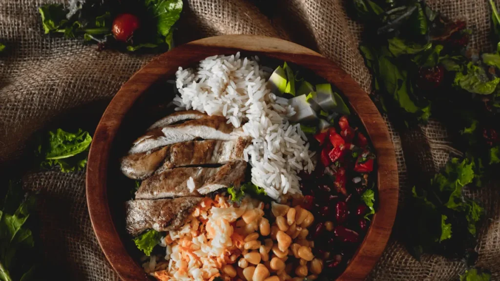 High-protein high-fiber meal bowl with chicken, rice, beans and vegetables