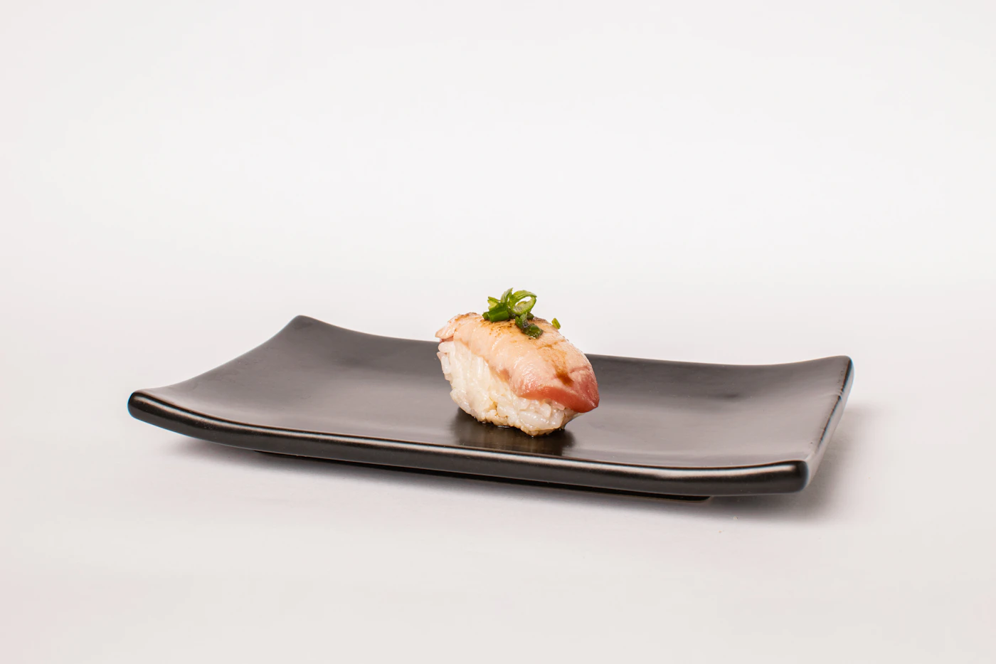 Nigiri sushi served on a dark plate