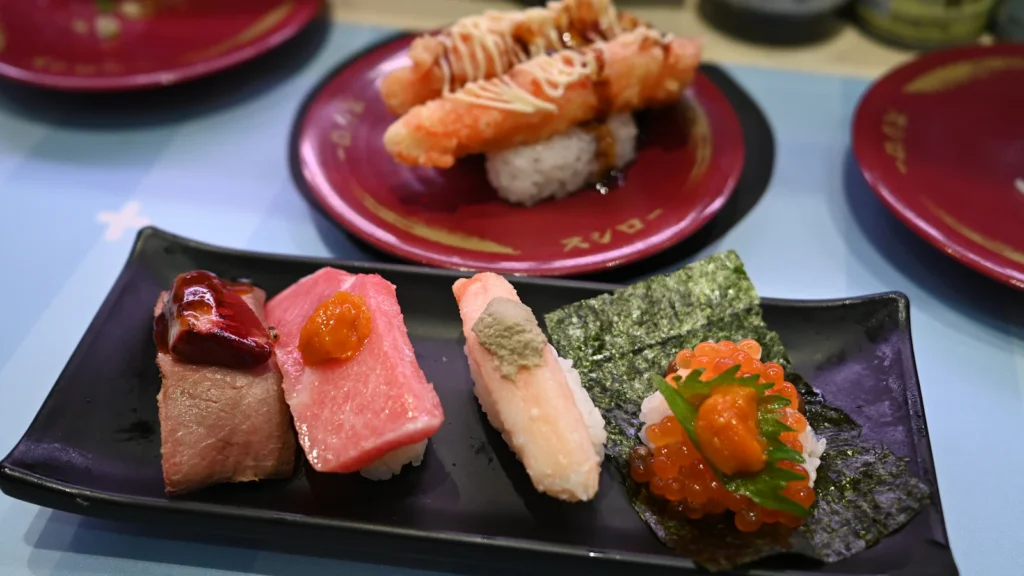 Assortment of nigiri sushi and sashimi on a black plate