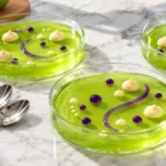 Shallow lime gelatin desserts decorated with tiny pudding dots and purple edible gel