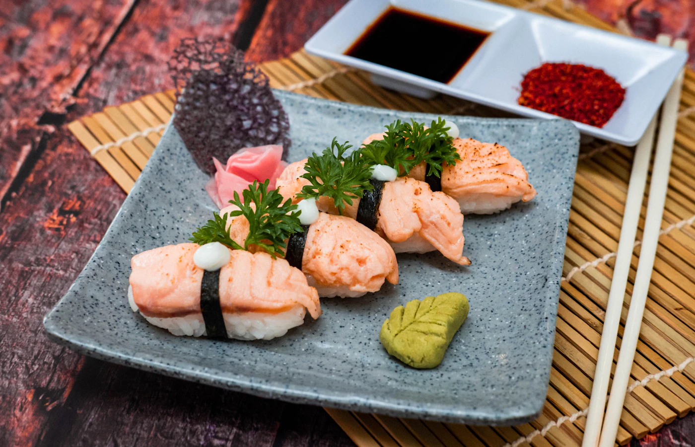 Salmon nigiri sushi served with chopsticks and soy sauce